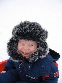 Cute smiling child with eyes closed during winter