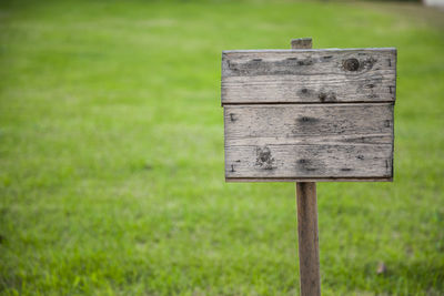 Close-up of wooden board on grassy field