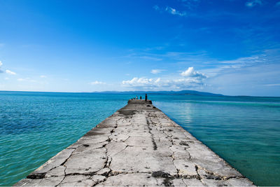 Pier over sea against blue sky