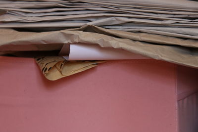 Close-up of paper stack on table against wall