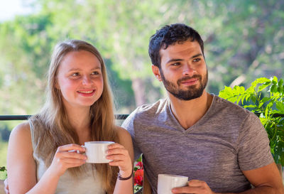 Young couple looking away while having coffee