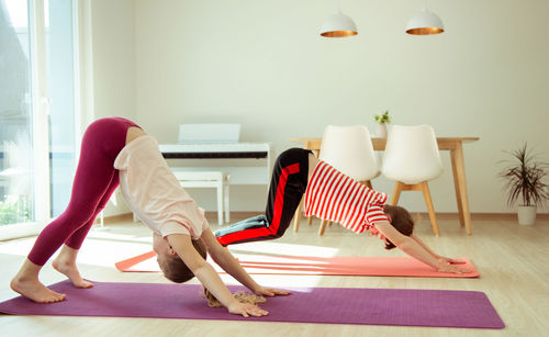 Siblings practicing yoga at home