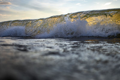 Surface level of beach against sky during sunset