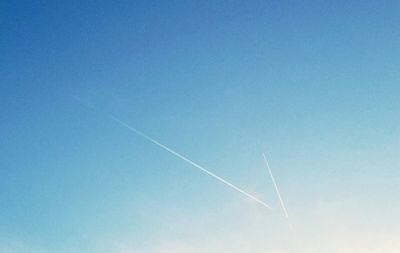 Low angle view of vapor trail against clear blue sky