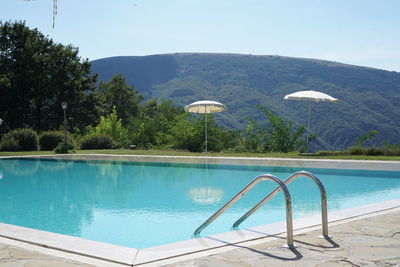 Fountain in swimming pool against sky