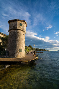 Historic building by sea against sky