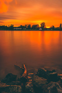 Scenic view of lake against orange sky