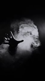 Man smoking against black background