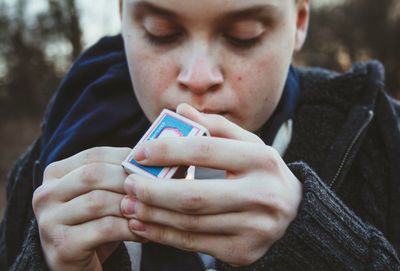 Close-up of a teenage boy lighting cigarette