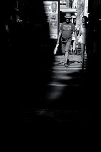 Low section of woman walking on illuminated city at night