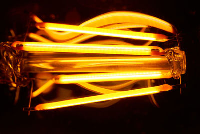 Close-up of illuminated yellow lights against black background