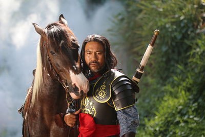 Portrait of man in warrior costume with horse