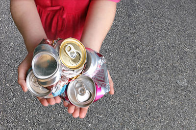 Low section of child holding camera on metal