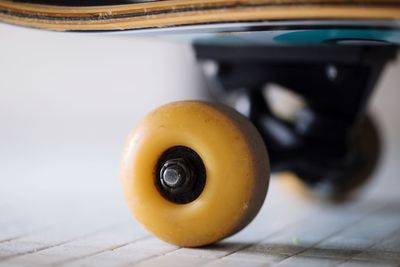 Close-up of yellow skateboard wheel on floor