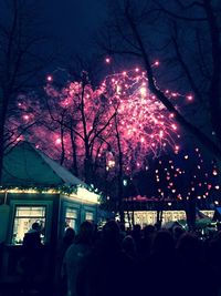 Illuminated christmas tree in city against sky at night