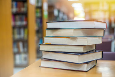 Stack of books on table in library