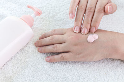 Cropped hands of woman applying lotion