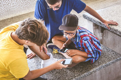 High angle view of friends using mobile phone