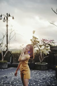 Rear view of woman standing against the sunset