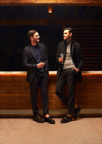 Full length of young man standing against wall