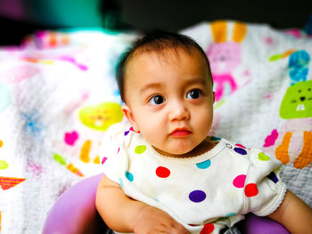 Portrait of cute baby boy on bed