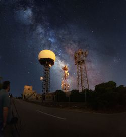 Low angle view of communications tower against sky at night