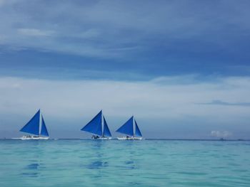 Sailboat in sea against sky