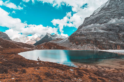 Scenic view of lake by mountain against sky