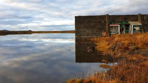 Reflection of building on lake against sky