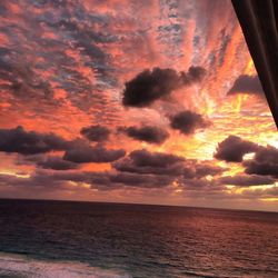 Scenic view of sea against cloudy sky at sunset