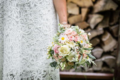 Midsection of woman holding rose bouquet