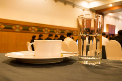 Cup and drinking glass on table