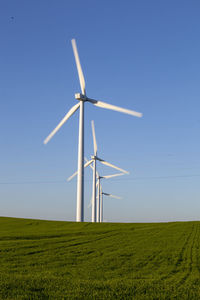 Windmill on field against clear sky