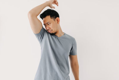 Full length of young man standing against white background