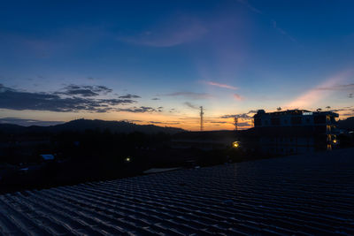 Illuminated buildings against sky at sunset