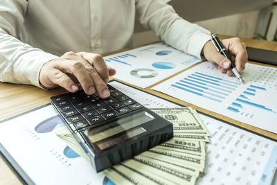 Midsection of businessman working over graph in office