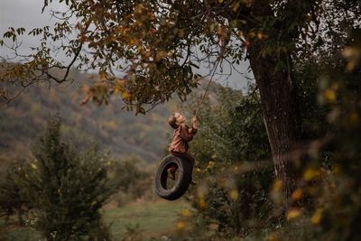 Person with umbrella on tree during autumn