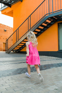 Full length of young woman walking on footpath