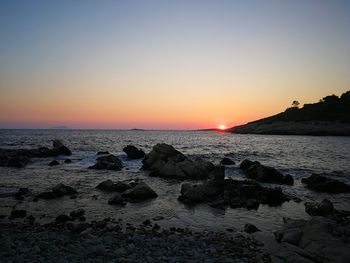 Scenic view of sea against clear sky during sunset