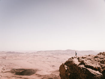 Man standing on cliff against sky