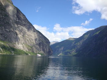 Scenic view of lake by mountains against sky