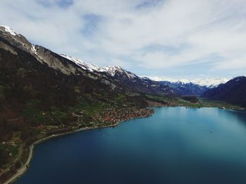 Scenic view of lake by mountains against sky