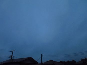 Low angle view of silhouette roof against clear blue sky