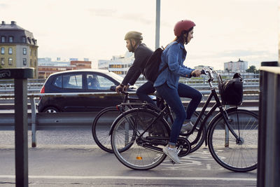 Side view of man riding bicycle on street