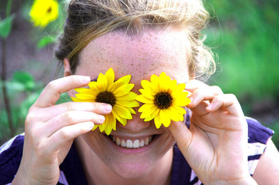 Close-up of smiling woman with yellow flowers