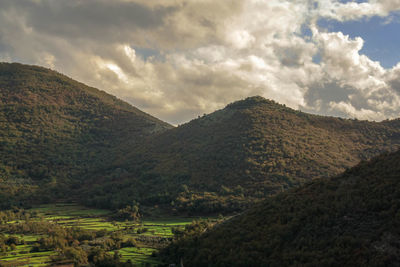 View of the valley with mountain peaks in the sky among the clouds