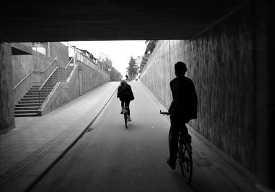 Rear view of man walking in tunnel