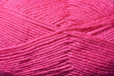 Woolly threads for knitting the color fuchsia as a background.