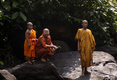 Group of people sitting on stone wall