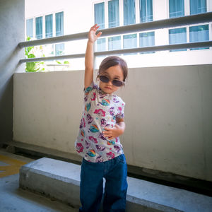 Full length of cute girl standing against wall